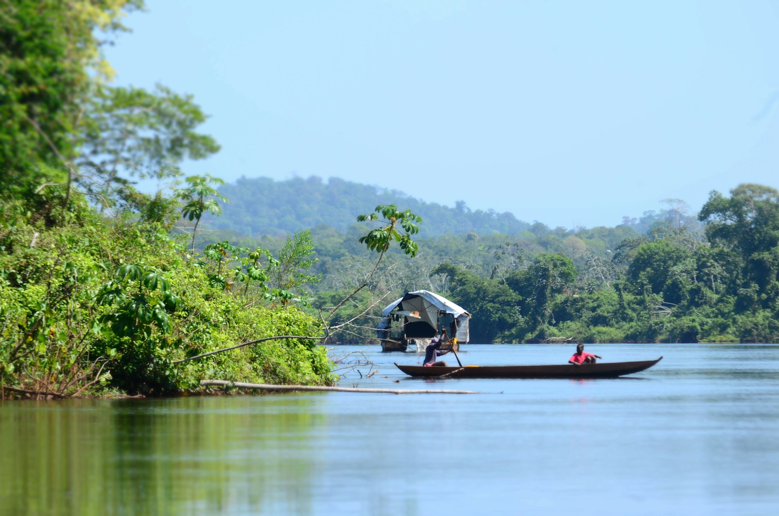 Een boot op een brede rivier in het binnenland van Suriname